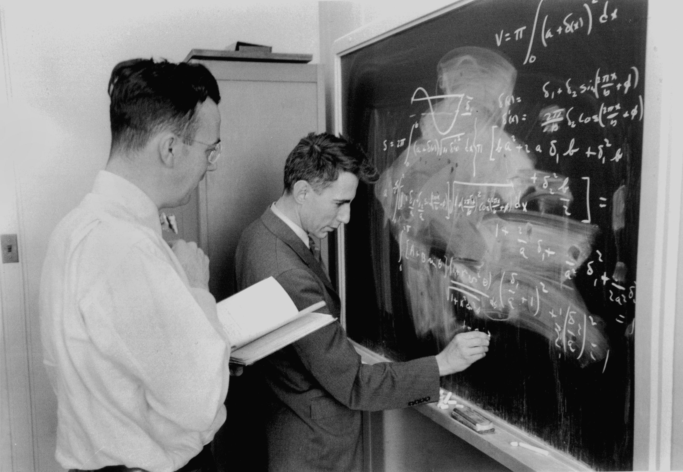 Claude Shannon working at a blackboard with colleagues at Bell Labs.